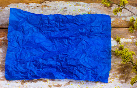 blue crumpled sheet of paper on old boardsの写真素材