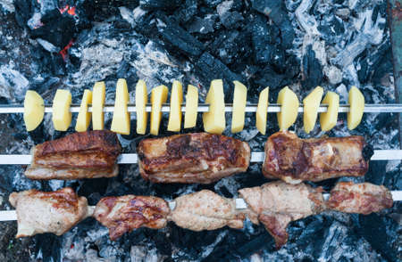 preparation of a shish kebab from pork meat on coalsの写真素材