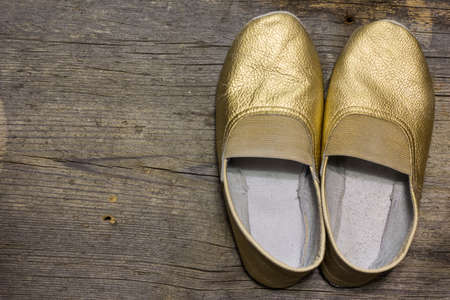 gilded gymnastic slippers from skin on a floorの写真素材