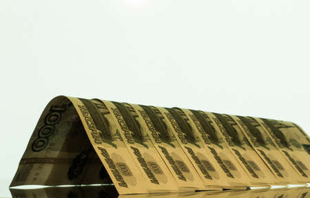 the bent banknotes are laid out in a row on the reflecting surfaceの写真素材