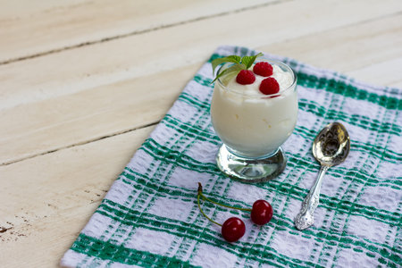 glass with dairy yogurt and cherry berries on a napkin