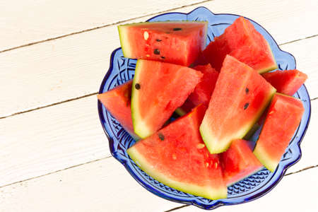 the water-melon sliced by triangular slices in a blue glass vaseの写真素材