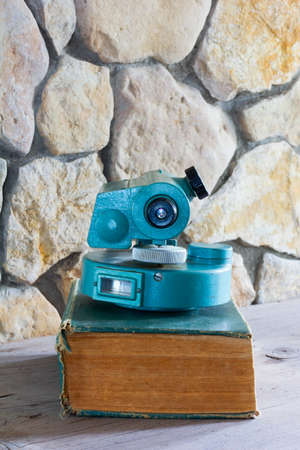 the old measuring instrument on the thick book and a stone wall on a background closeupの写真素材