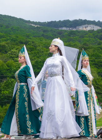 Adygea, RUSSIA - JULY 25 2015: Female dancers in traditional costumes Circassian green hills in the background. Ethnic festival in the foothills of the Western Caucasus in Adygeaのeditorial素材