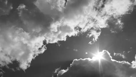 in the sky the sun breaks through the clouds. Black and white photoの写真素材