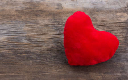 Old textured background of cracked barn boards and the red plush heart. The concept of love, relationship, Valentine's day. Top view. Free space for text. Copy spaceの写真素材