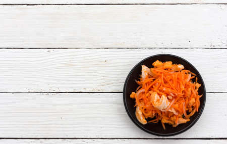 Korean salad made of grated carrots with red fish and onion marinated on white wooden boards. Copy space. Free space for text, Close-up, top viewの写真素材