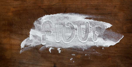 Old wooden cutting board with the word flourの写真素材