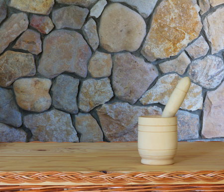 wooden mortar with pestle on a beautiful table against the wall of stone. selective focus. Copy space. Free space for textの写真素材