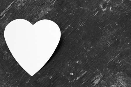 Valentine - paper white heart against a black wooden background. Copy space. Free space for text, Close-up, top view, Black and white photoの写真素材