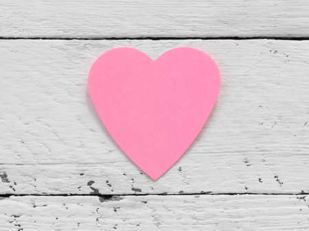 Valentine - paper pink heart against a white painted surface. Copy space. Free space for text, Close-up, top viewの写真素材