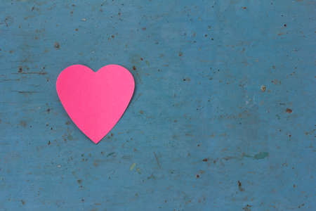 Valentine - paper pink heart against a blue painted surface. Copy space. Free space for text, Close-up, top viewの写真素材