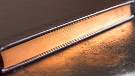 a closed book with gold color edge. shallow depth of fieldの写真素材