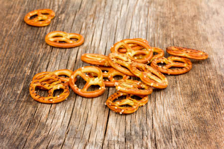small salted pretzels scattered on the old wooden table in the cracks. selective focusの写真素材