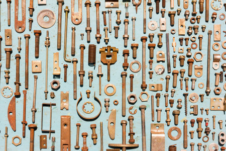 set of old rusty metal screws, nuts and bolts on a blue background. Flat lay, top view