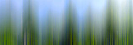 textured abstract blurred background with vertical stripes of different shades of greenの写真素材