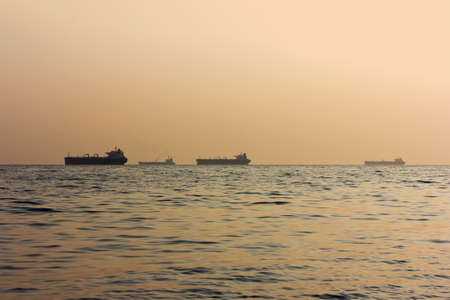 silhouettes of cargo ships at sea at sunset, selective focusの写真素材