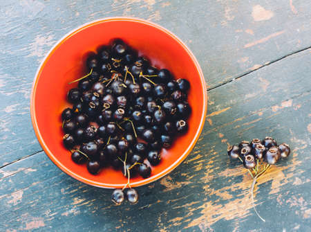 Fresh Berries Of Black Hawthorn In The Black Bowl On The Old Wooden Table Closeup. The View From The Topの写真素材