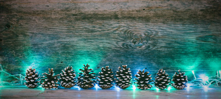 old wooden background with fir pine cones and garland with space for text. the concept of new year...