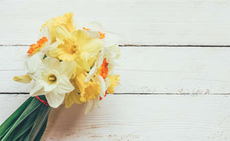 a bouquet of fresh flowers Narcissus on white wooden background with space for text, close-up top viewの写真素材