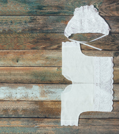 photo of a cap and shirt for a newborn on an old rustic wooden table closeup, top view. with space...