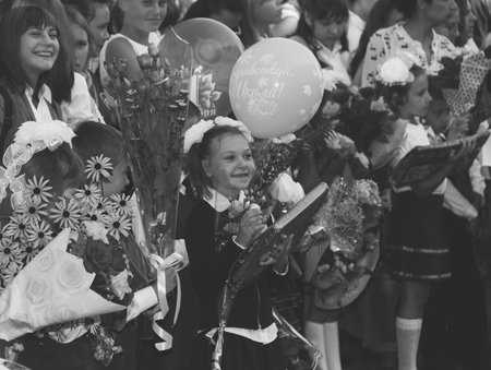 Adygea, Russia - September 1, 2017: happy children enrolled in the first grade with gifts in hand with teachers and pupils at the school the solemn ruler in day of knowledge, a black and white photoのeditorial素材