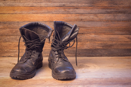 old leather black male shoes ankle boots on a wooden background front view close-up with space for...