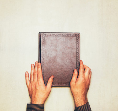 The book is in the hands of a man from above. mock up for text, congratulations, phrases, lettering