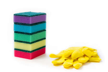 pile of colorful sponge and yellow rubber gloves for wet cleaning and washing dishes on white background with space for textの写真素材