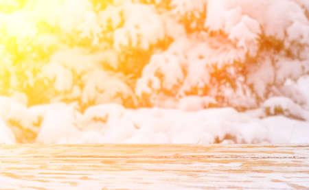 winter blurred natural background in the sunlight with a wooden table and a mounting area for the placement of objects. mock up for text, congratulations, phrases, letteringの写真素材