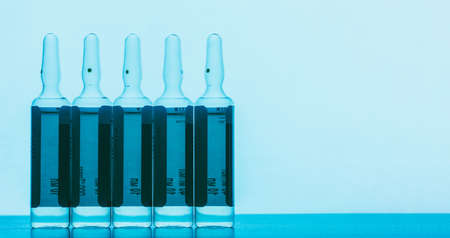 the ampoules with solution for injections on a blue background with space for text,の写真素材