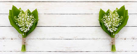 bouquet of flowers of fragrant lily of the valley on a white wooden background with copy space. mock up for text, for phrases, for letteringの写真素材