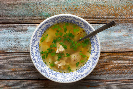 diet chicken soup with green parsley on a wooden table close-up top viewの写真素材