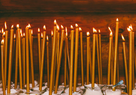 many burning wax candles in the templeの写真素材