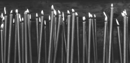 many burning wax candles in the temple, black and white photoの写真素材