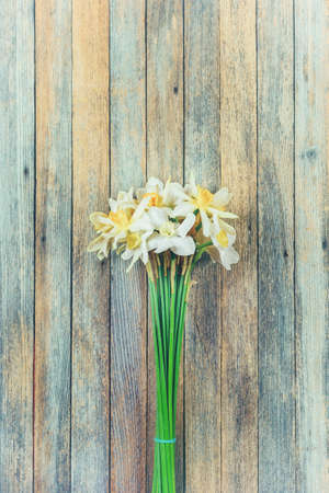 bouquet of daffodils flowers on wooden retro grunge background closeupの写真素材