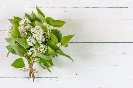 bouquet of white lilac flowers on white wooden background with copy spaceの写真素材