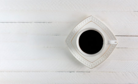 black coffee Cup on white wooden background, top view with copy space, flat lay