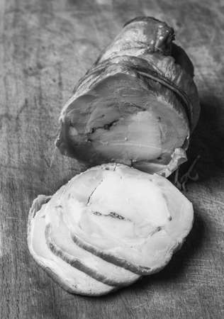 meat loaf from chicken and pork with garlic chopped slices on a wooden cutting board closeup black and white photoの写真素材