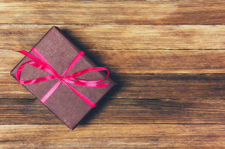 brown gift box on wooden background with copy space, flat lay top view