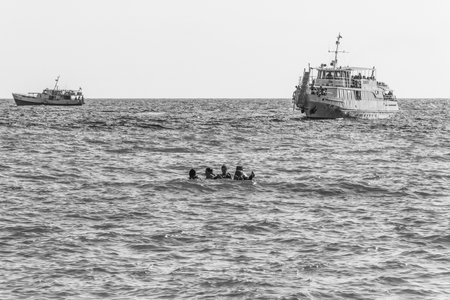 Sochi, Russia - August 21, 2018: pleasure boats and young boys and girls swim in the sea, black and white photoのeditorial素材