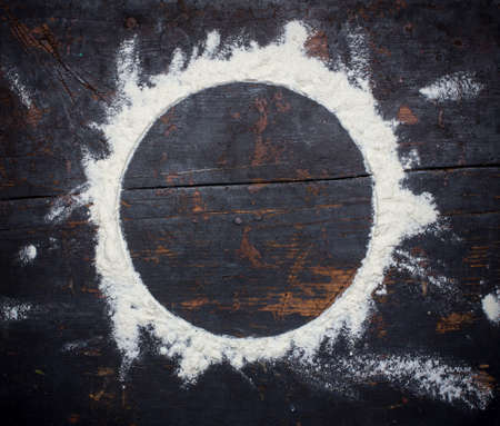 round flour frame on old black wooden retro background with copy spaceの写真素材