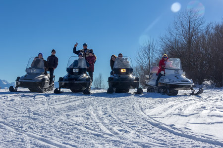 Adygea, Russia - January 23,  2017: Young happy men, women and children on the snowmobiles Yamaha on a snowy slope winter Sunny dayのeditorial素材
