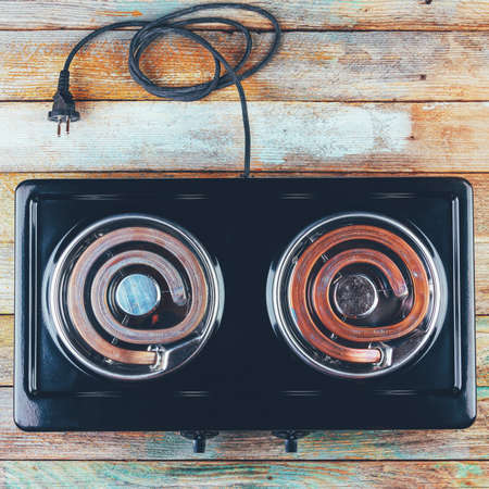 electric stove with two electric forks on a wooden table, top view close-upの写真素材