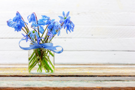 bouquet of bluebell flower in a vase on the table on a white background with copy space closeup