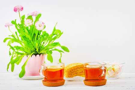 still life with cups of tea, pieces of cake, a bouquet of pink flowers in a pink pot and...