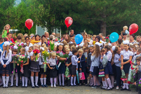 Adygea, Russia - September 1, 2018: children enrolled in the first class with bouquets of flowers and balloons in the hands, teachers and high school students on the school solemn paradeのeditorial素材