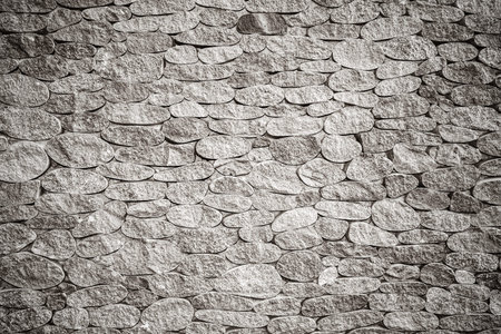 background texture of grey stone wall with vignette, black and white photo