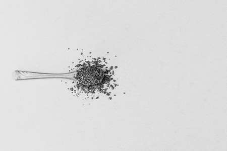 wooden spoon with instant granular coffeeon gray background top view with copy space, minimal art, black and white photoの写真素材