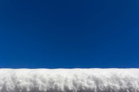 a thick layer of snow on a against of clear blue sky, background with a copy spaceの写真素材